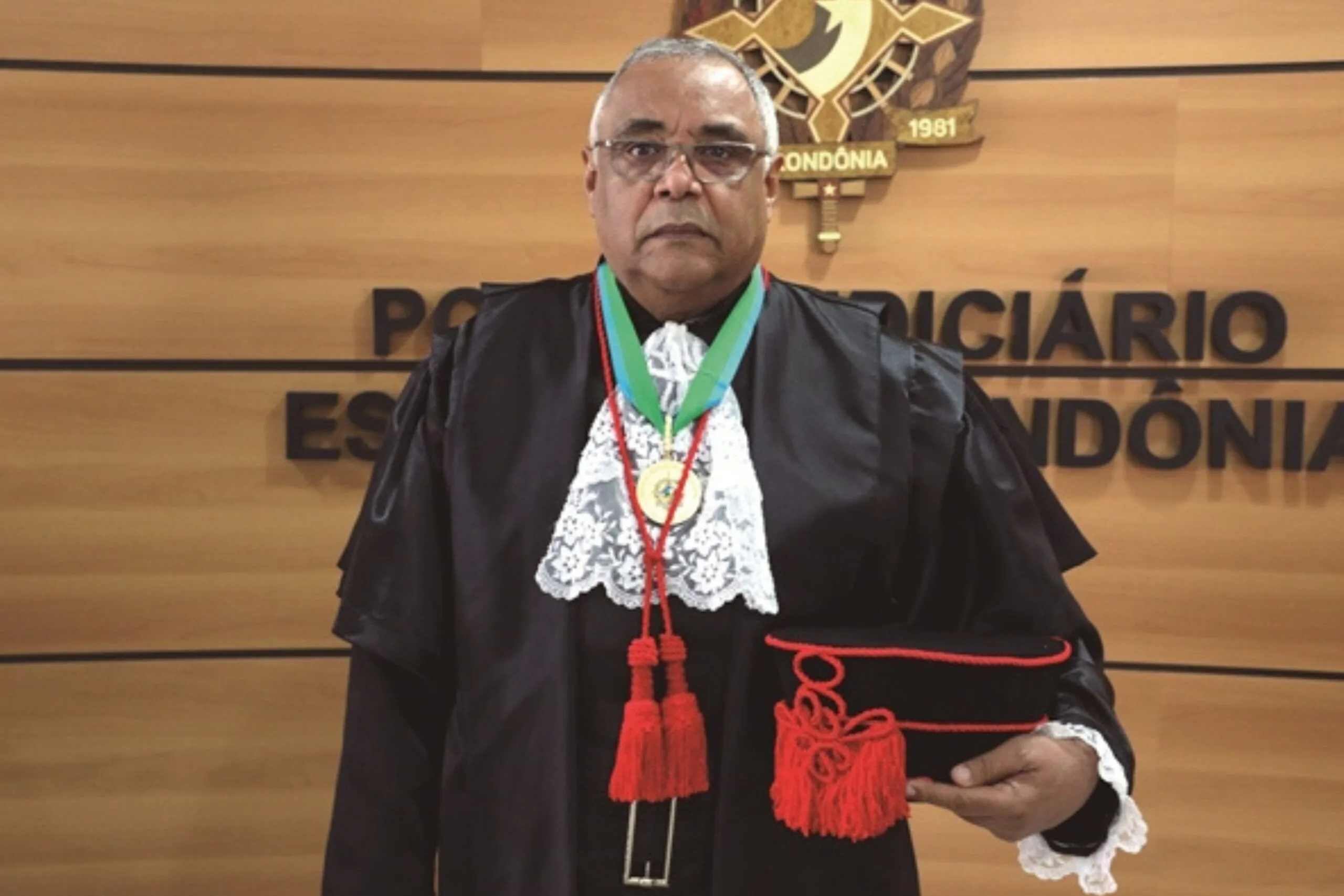 Homem negro trajado com roupaz de juiz posado para foto 